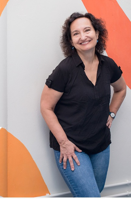 Inga smiling against an orange and white wall